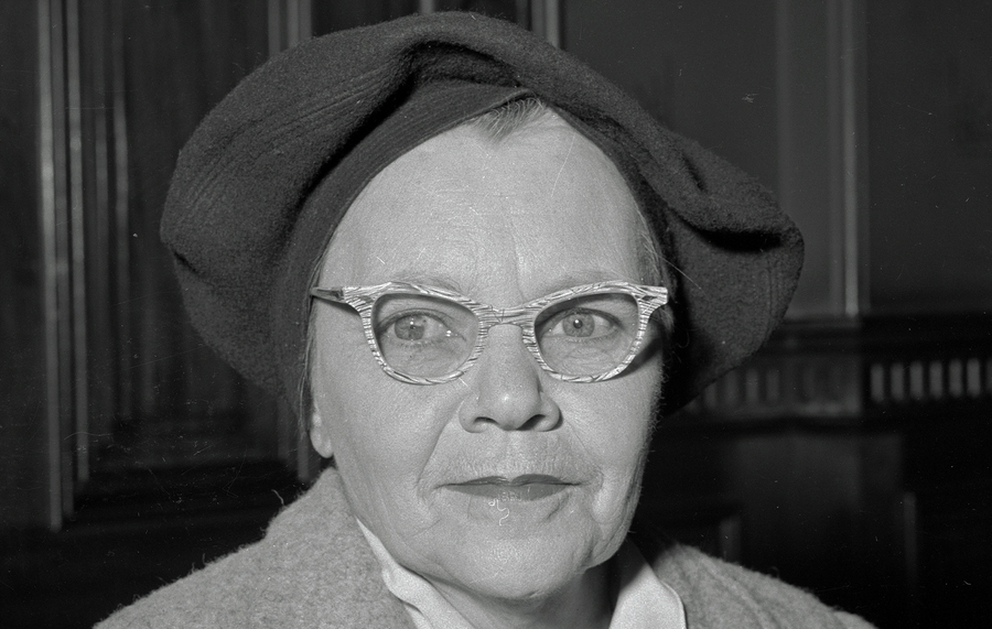 Black and white photograph of a woman wearing glasses and a hat