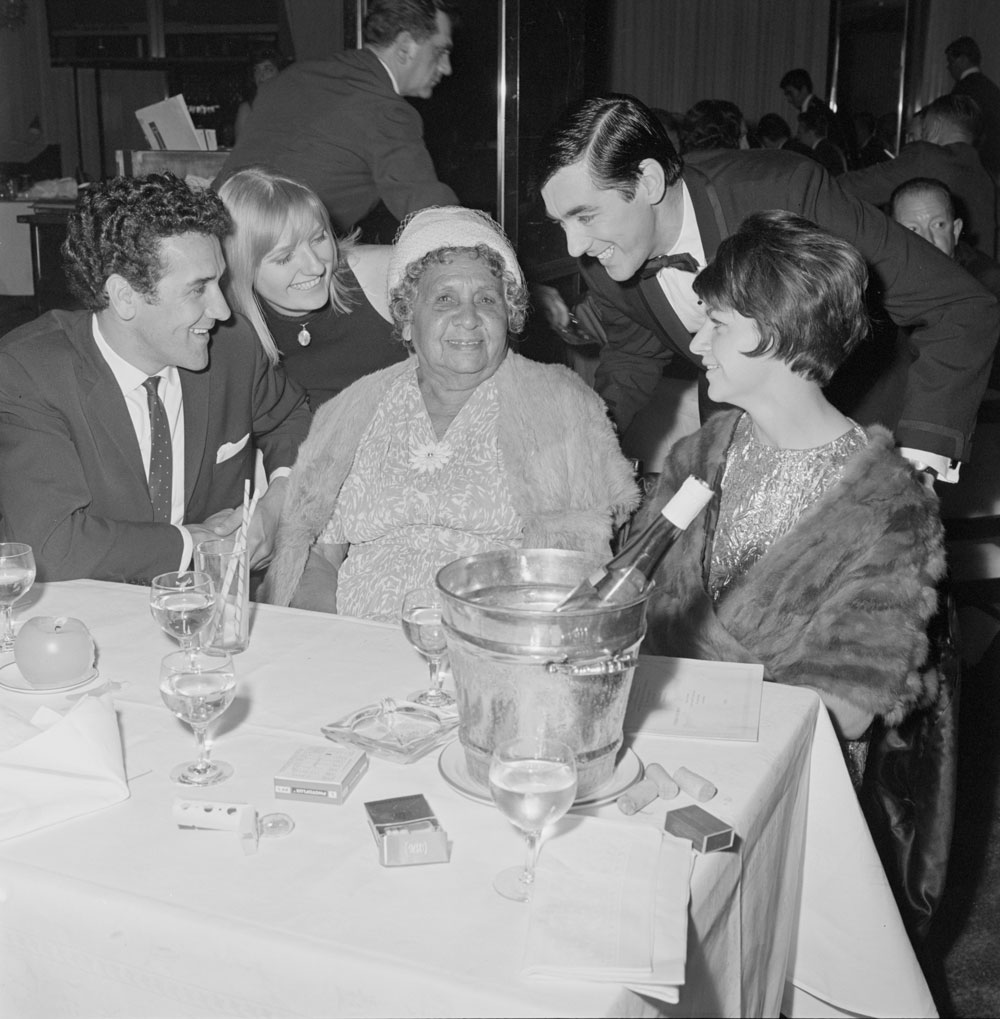 Image 1 of 4 - A black-and-white photograph of Charles Perkins and members of his family enjoying a night out at the Silver Spade Room at the Chevron Hilton Hotel, Sydney, May 1966. Photograph by Alec Iverson.