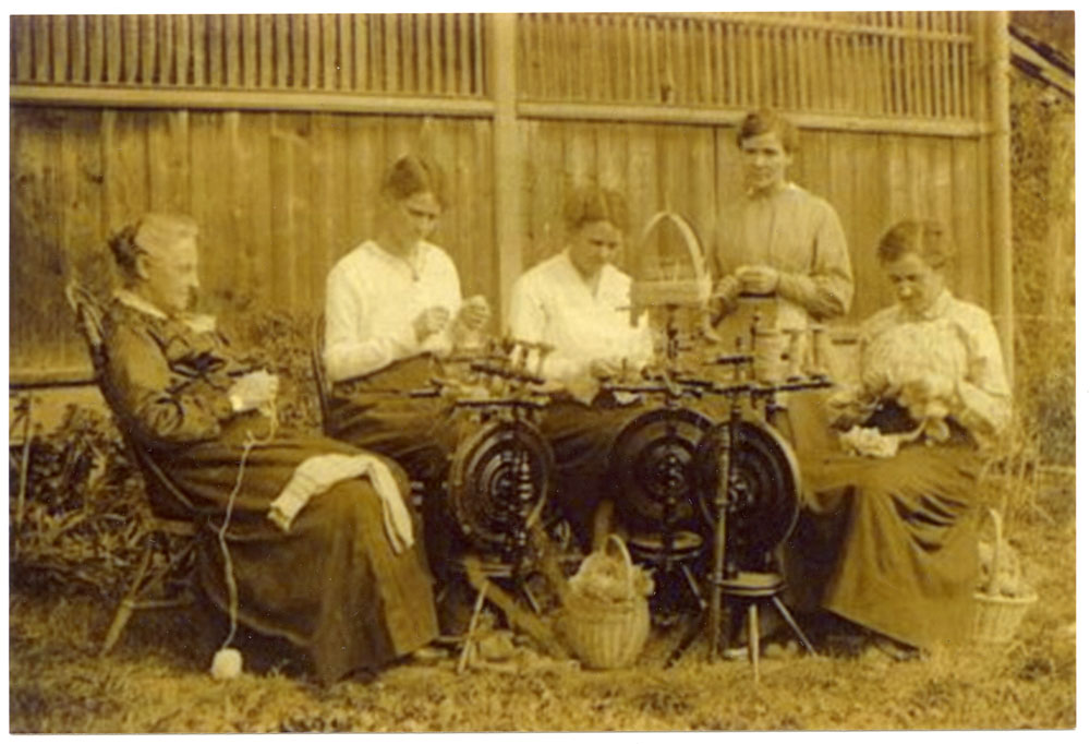 A group of local women from the Camden Red Cross sewing circle. While some are spinning yarn for knitting socks, others knit and sew articles of clothing for injured troops. Taken circa 1917, photographer unknown. 