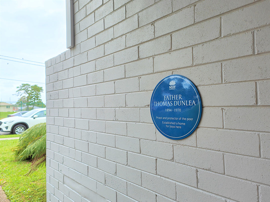 Image 4 of 5 - Brick wall with a blue plaque